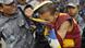 Nepalese police officers snatch a Tibetan flag from a Tibetan protester demonstrating in front of the UN office in Kathmandu