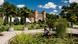 A mansion amid palm trees and a decorative pond at the Botanical Gardens, Karlsruhe. 