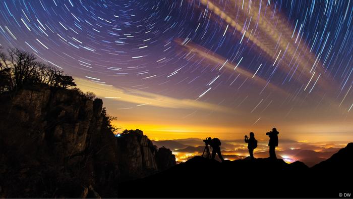 People looking through telescopes and cameras at sky and stars